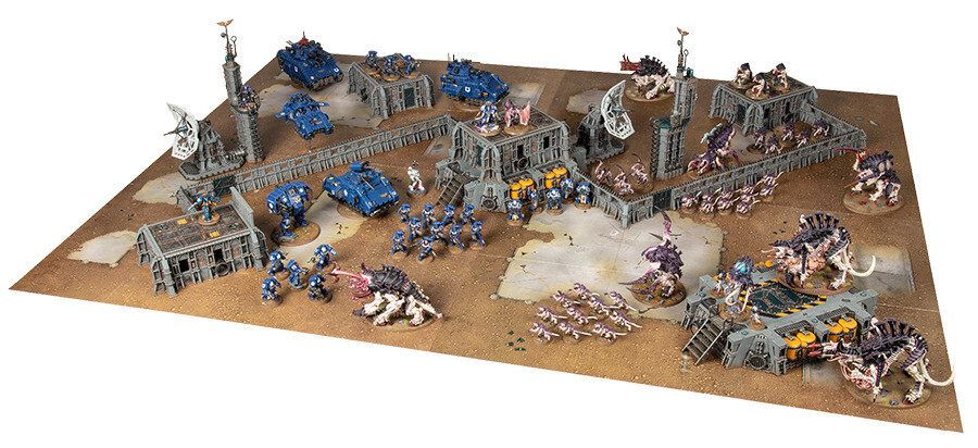 This Strike Force battlefield features a single story sealed building in each battlefield quarter and a two story one in the centre. It also features barricades running in a line across the battlefield from one corner to another and has several smaller structures that do not block visibility but do provide cover scattered across the area. It is ideal for matched play because it has line of sight blocking terrain that restricts visibility from one side of the battlefield to the other and a good amount of scenery that provides cover spaced evenly across the whole battlefield. If this battlefield had less terrain it would give an advantage to armies that rely on shooting over melee.